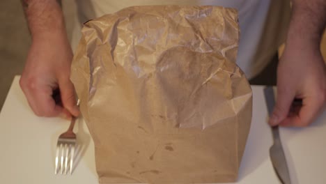 Parcel-packed-meal-in-brown-paper-with-fork-and-butter-knife-arranged