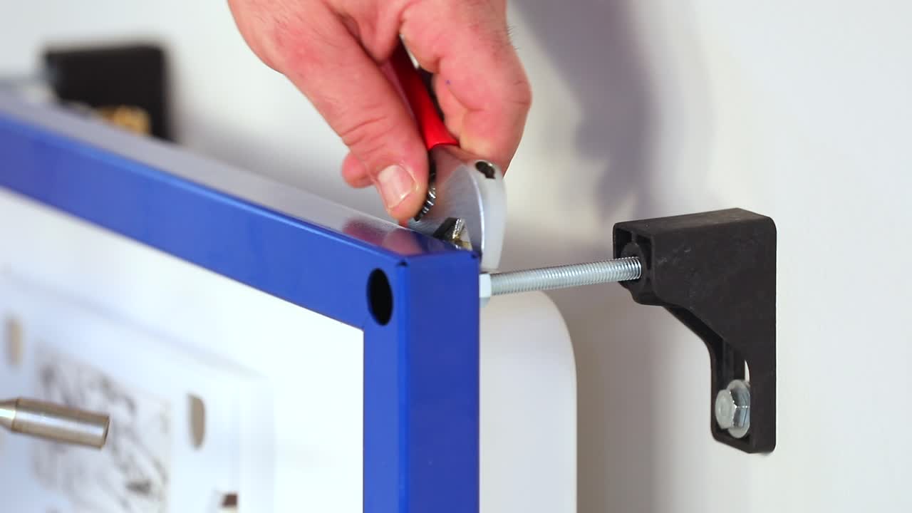 el maestro aprieta el perno con una llave y un destornillador