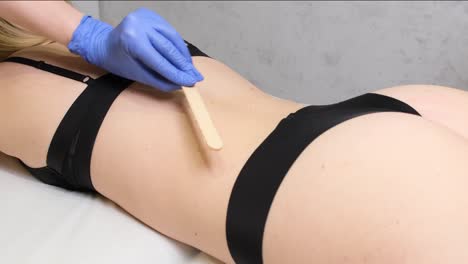woman getting back waxing treatment