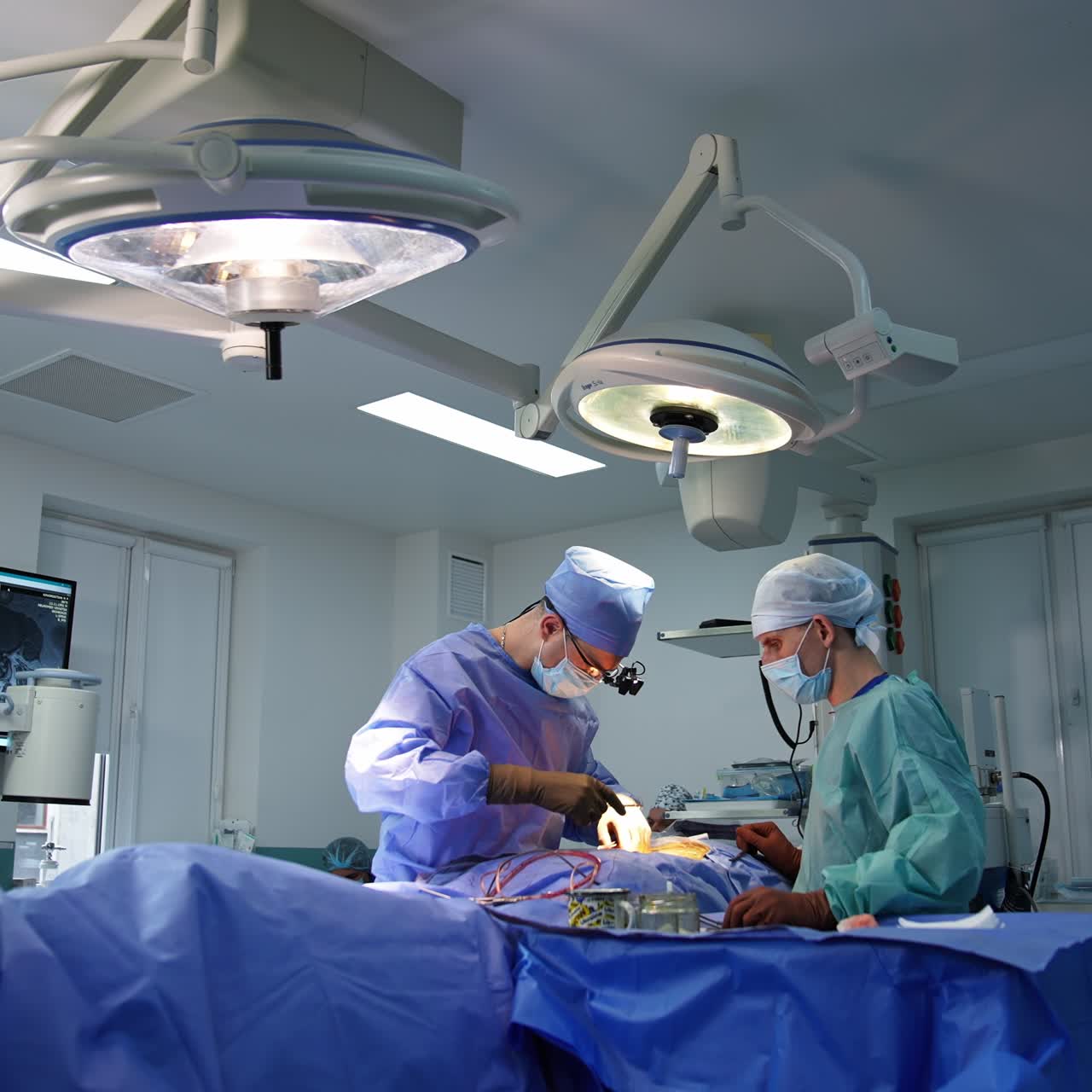 Neurosurgery specialist at final stage of operation. Doctor sewing the patient using the forceps. Modern surgery room backdrop