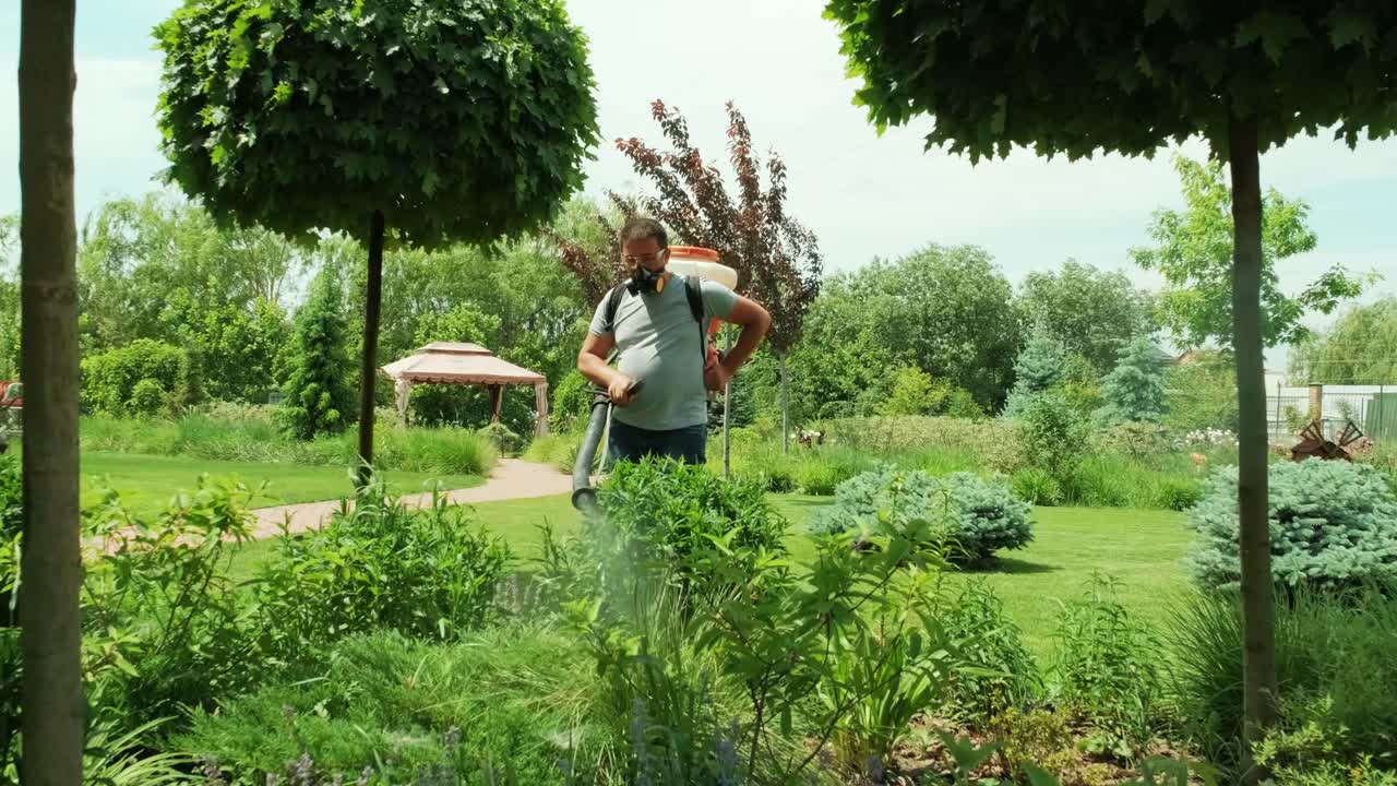 생태적 살충제를 스프레이하는 농부: 보호 마스크와 유리 안경으로 나무와 관목을 우는 농부: 독성 살충제, 살균제, 살충제를 뿌리는 사람: 정원사가 정원을 유지합니다.