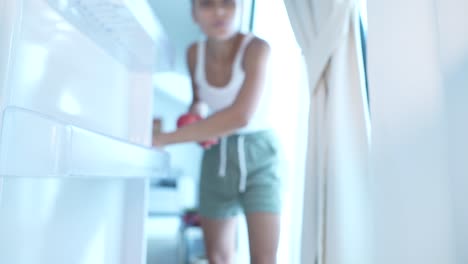 mujer mirando dentro de un refrigerador