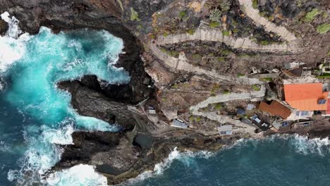 aerial view of dramatic rocky coastline with ocean waves and staircase path