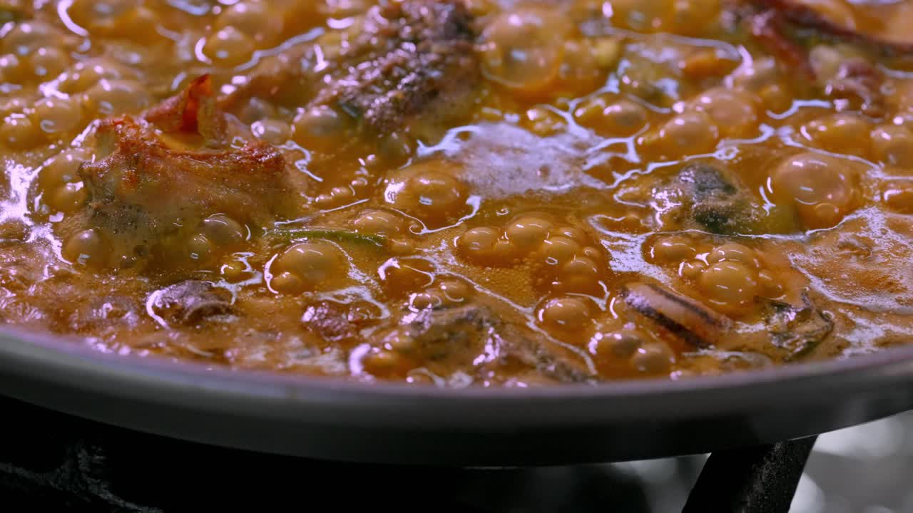 primer plano de una paella con arroz hirviendo