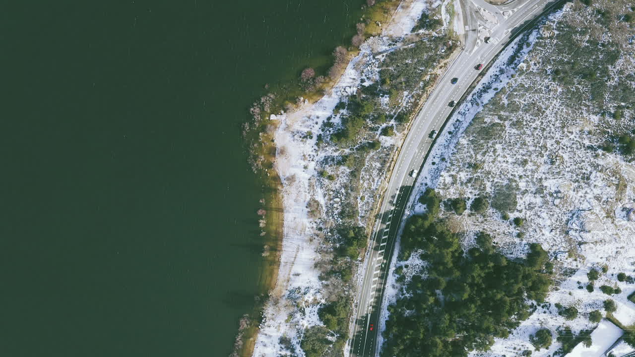 кадры с беспилотника дороги с автомобилями рядом с водохранилищем в горах в мадриде