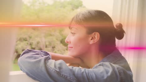 animation of light trails over caucasian woman looking through window