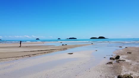 AERIAL:-Drone-is-Traveling-fast-right-to-left-Above-The-Low-Tide-Сoastline-with-Islands-on-the-Background