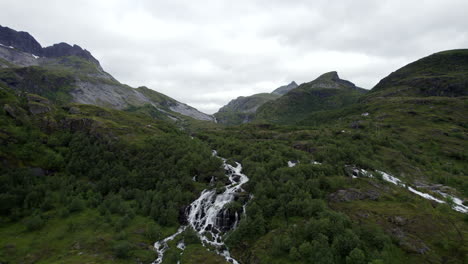 aerial forwarding shot of a waterfall coming from trolldalsvatnet on lofoten islands in norway