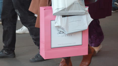people carry multiple bags and presesnts as they walk down the highstreet through the christmas market