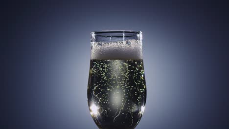 bubbles of champagne wine disappear from the beverage slow motion bubbles of champagne wine disappear from the beverage sparkling in tall glass alcohol drink is poured to brim and raised foam shines in light side view blue background slow motion