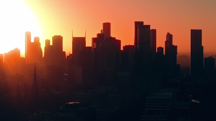 Tomada de Estabelecimento Cinematográfica com Drone do Horizonte de Melbourne ao Pôr do Sol com Névoa Laranja Quente e Fundo com Horizonte Escuro