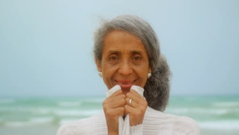 Vista-Frontal-De-Una-Feliz-Mujer-Afroamericana-Senior-Activa-Parada-En-La-Playa-4k