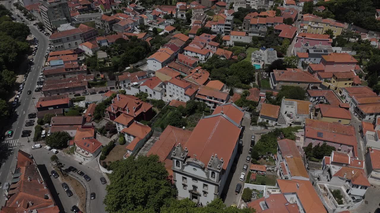aerial approach to the main church in foz do douro surrounded by red roofs and narrow streets