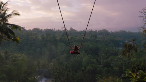 Mujer-Turista-Balanceándose-Sobre-La-Selva-Tropical-Al-Amanecer-Viaje-Chica-Disfrutando-De-Vacaciones-Exóticas-Sentada-En-Un-Columpio-Divirtiéndose-Estilo-De-Vida-De-Vacaciones-Libertad-4k