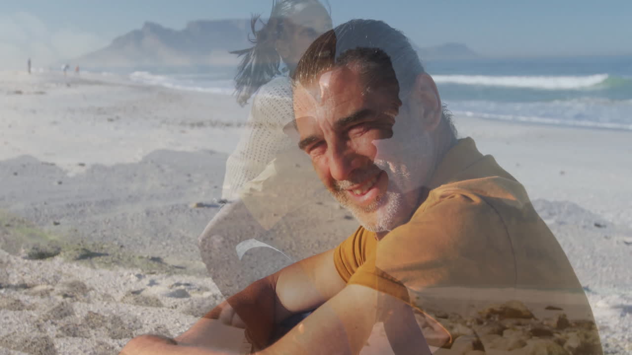 Sitting on beach, man smiling with animation of woman walking by ocean