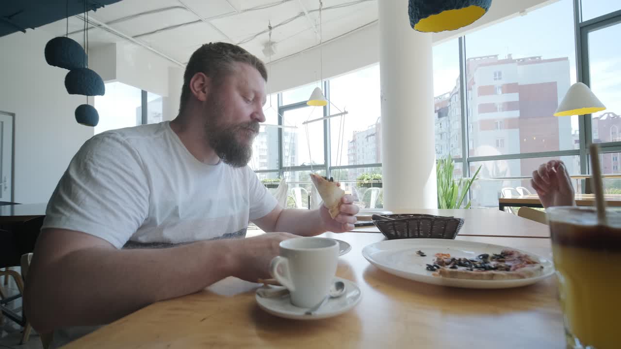 una pareja comiendo pizza en un restaurante.