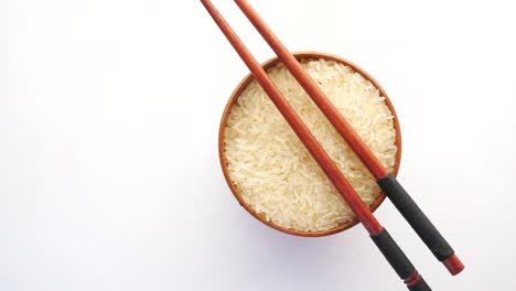 wooden bowl of rice with chopsticks