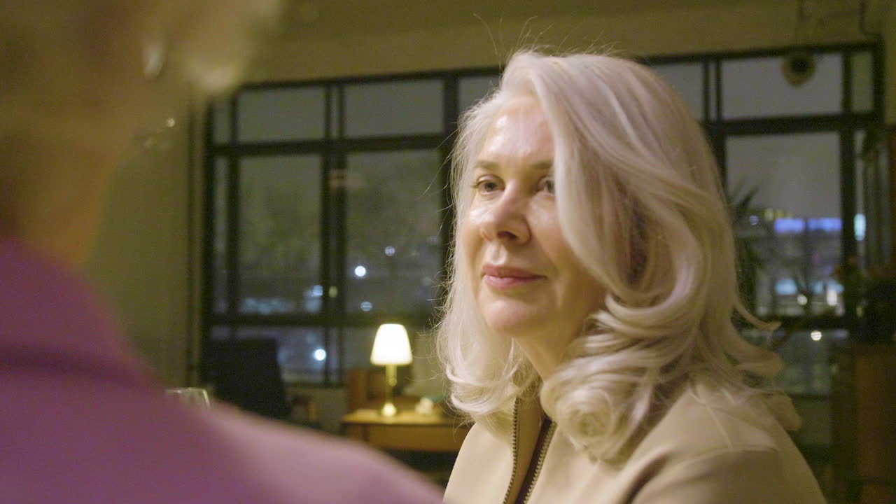 Senior Woman Talking While Sitting At Dinner Table At Home 1