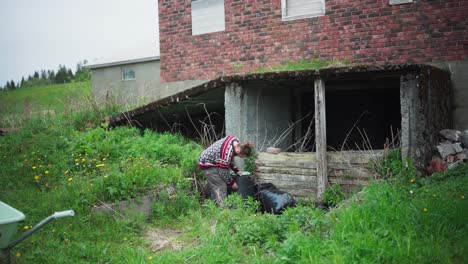 Mann-Repariert-Müll-Im-Grasbewachsenen-Hinterhof