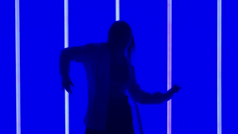 silhouette dance performance in neon blue light