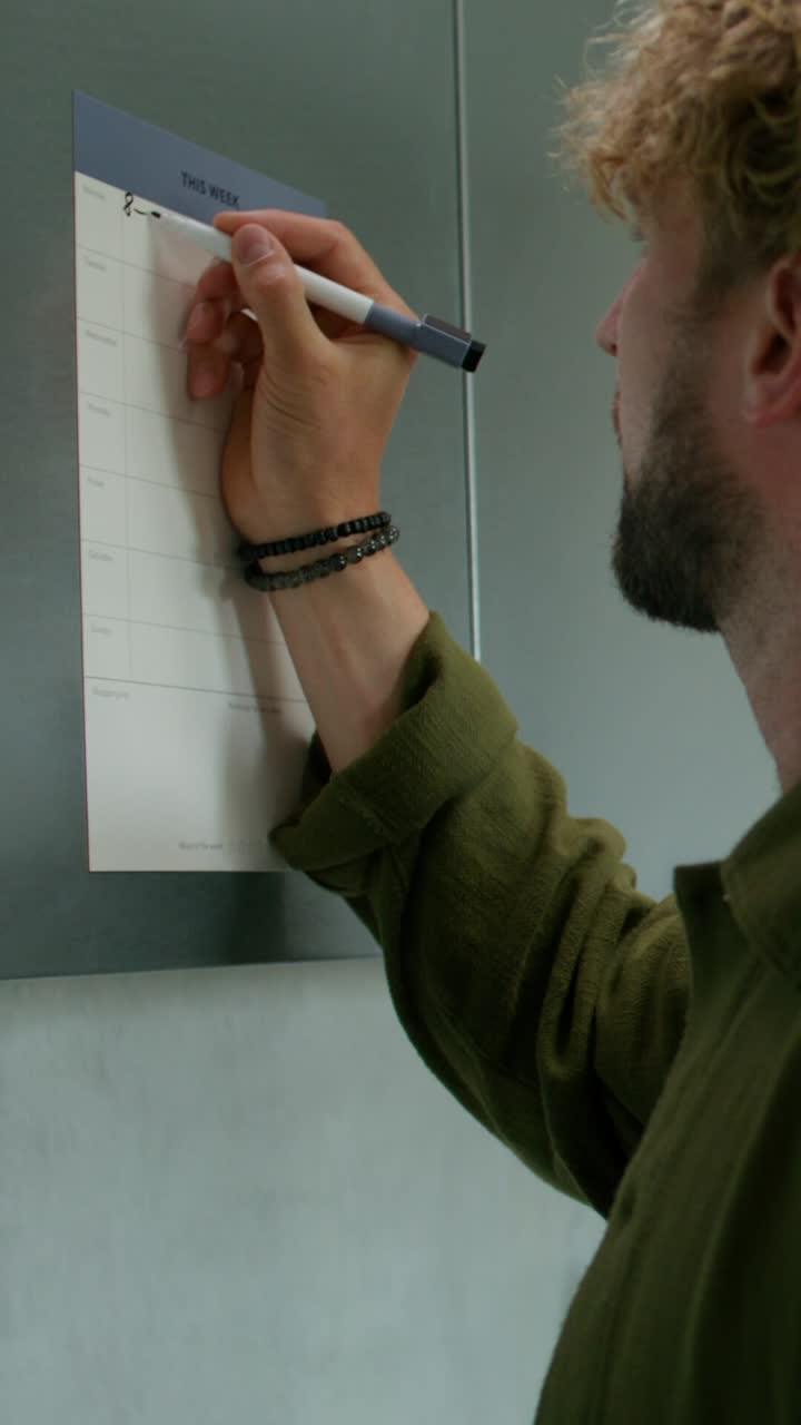 Person Writing on a Weekly Planner