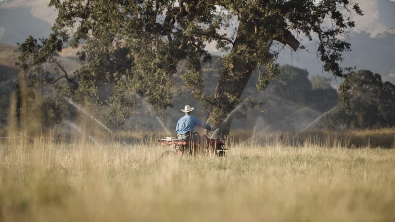 한 남자가 카메라를 쳐다보고 전지구 차량으로 돌아갑니다. 자동차 스포츠, 농장