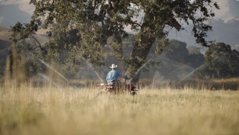 Man-looks-at-camera-and-turns-away-on-his-all-terrain-vehicle-|-Motor-sports-|-farming-field