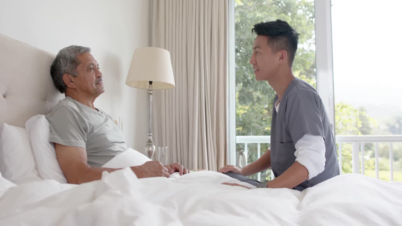 다양한 남성 의사가 고령 남성 환자와 함께 집에서 침대에서 논의하고, 느린 동작
