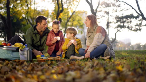 family having a picnic in the park during autumn