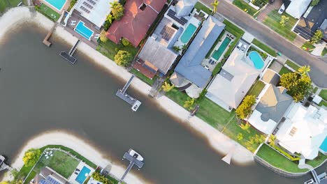 drone footage captures luxury homes along gold coast canals with clear skies and vibrant colors, highlighting modern architecture and waterfront living
