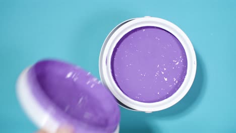 close shot of a hand opening can with purple paint