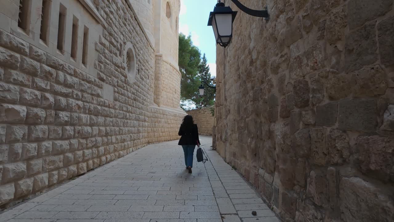Tourist walking in Jerusalem old city alley, Dormition Abbey. Slow motion.