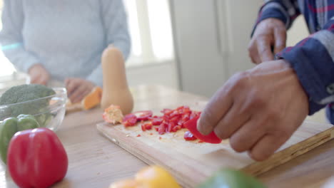 Fokussiertes-älteres,-Vielfältiges-Paar-Kocht,-Schneidet-Gemüse-In-Der-Küche,-Zeitlupe