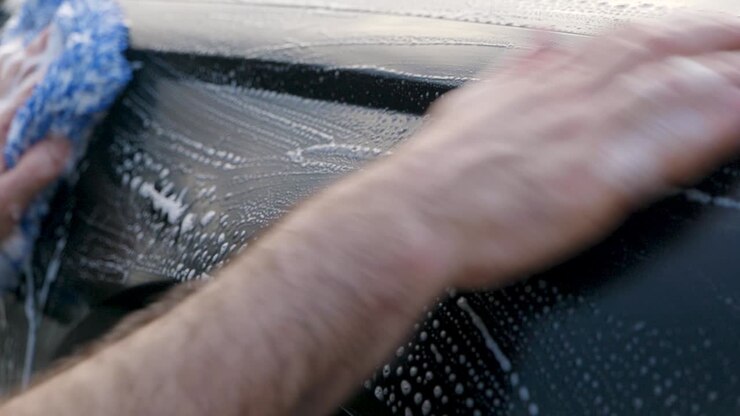 Trattamento con clay bar del parafango di un'auto nera.