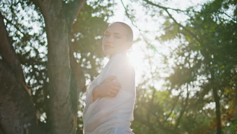 mujer relajada abrazándose a sí misma en la luz del sol de la naturaleza. niña soñadora disfrutando del sol