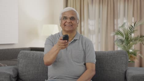 happy indian old man watching tv