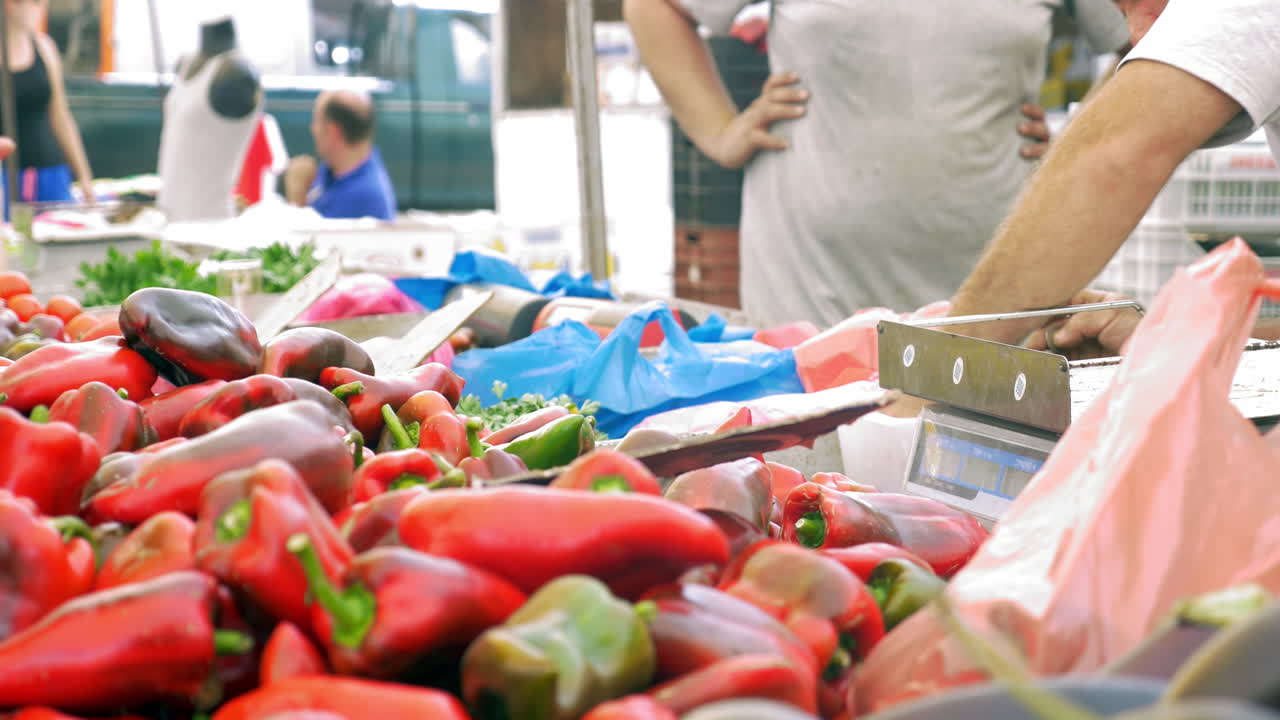 comprando pimientos rojos en el mercado callejero