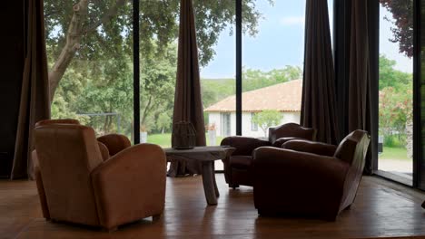 slow establishing shot of a seating area looking out floor to ceiling windows