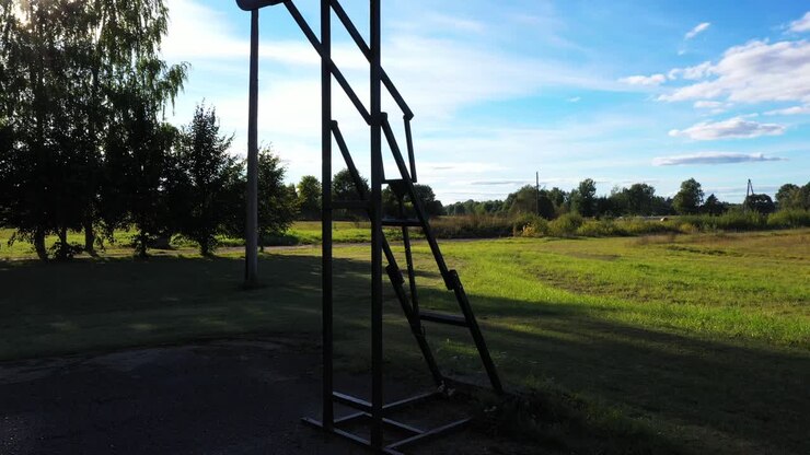 Vecchio tabellone e canestro da basket in un paesaggio rurale in una giornata di sole, ripresa ravvicinata in ascesa