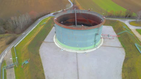 antena hacia el tanque de almacenamiento de crudo con techo flotante en un campo de gas