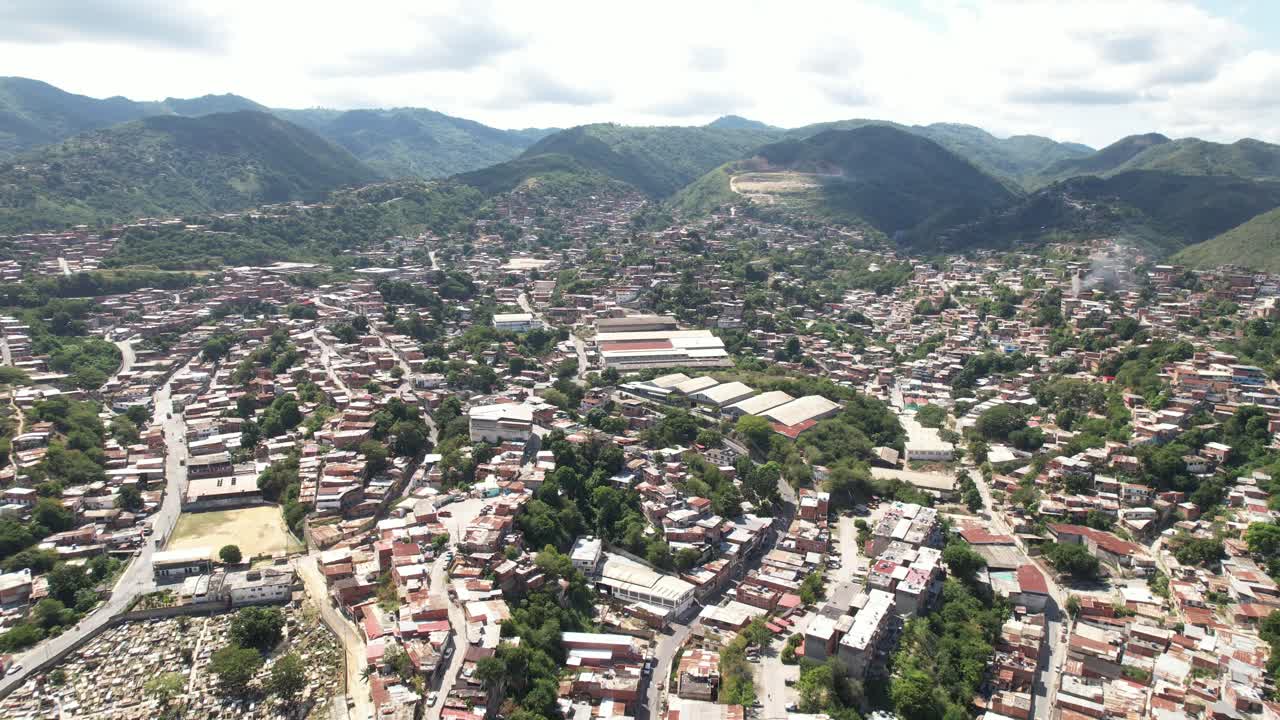 Aerial view moving forward over Guarenas, Venezuela, with houses and mountains visible