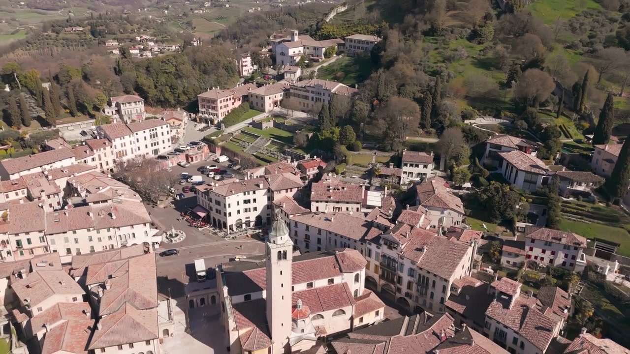 Vista aerea di una città collinare con edifici storici e piazza centrale ad Asolo, Italia.