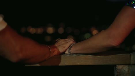 couple touching hands looking at the skyline at night romantic
