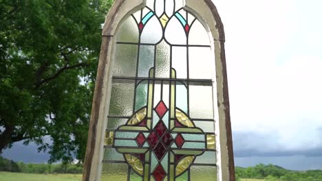 a colorful window pane sits in a field