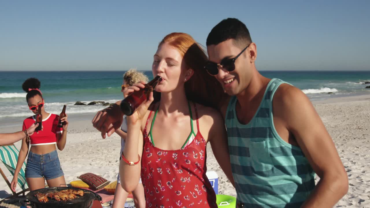 Giovani amici adulti che fanno un barbecue in spiaggia 4k
