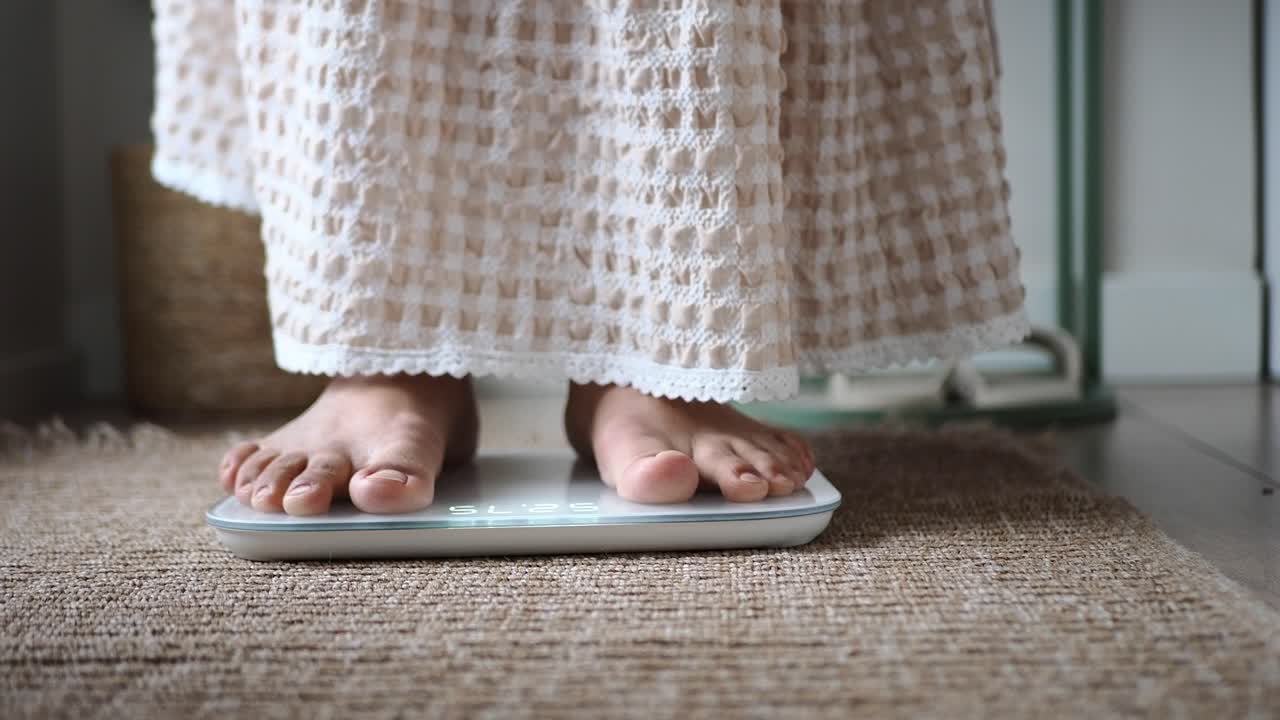 Person Stepping on Digital Weighing Scale to Check Weight