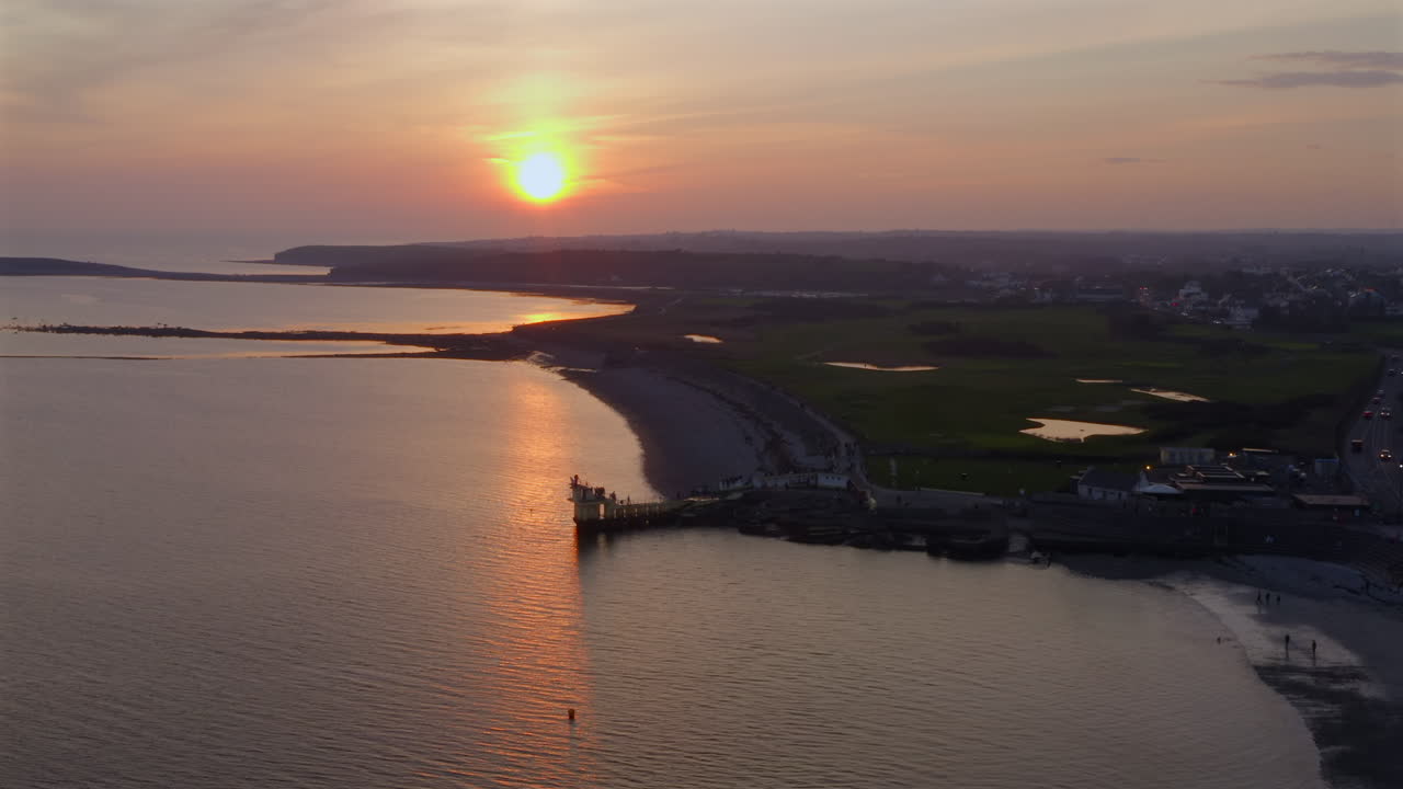 Aerial pullback of Blackrock Diving Board at Salthill Promenade, Galway Ireland, waves gently moving toward the shore