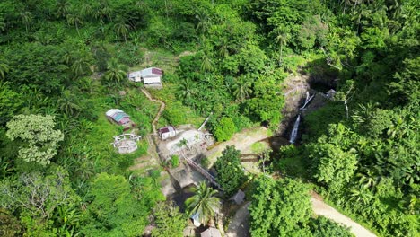 Aerial-parallax-above-home-in-baras-catanduanes-next-to-waterfall-among-palm-trees