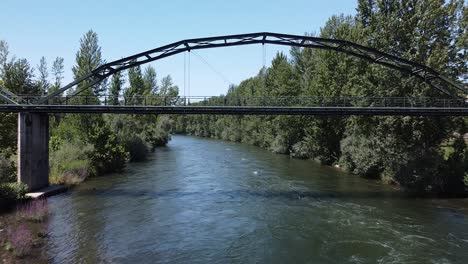 aerial view under a bridge on the sil river, sunny day, in o barco de valdeorras, galicia, spain - low, dolly, drone shot