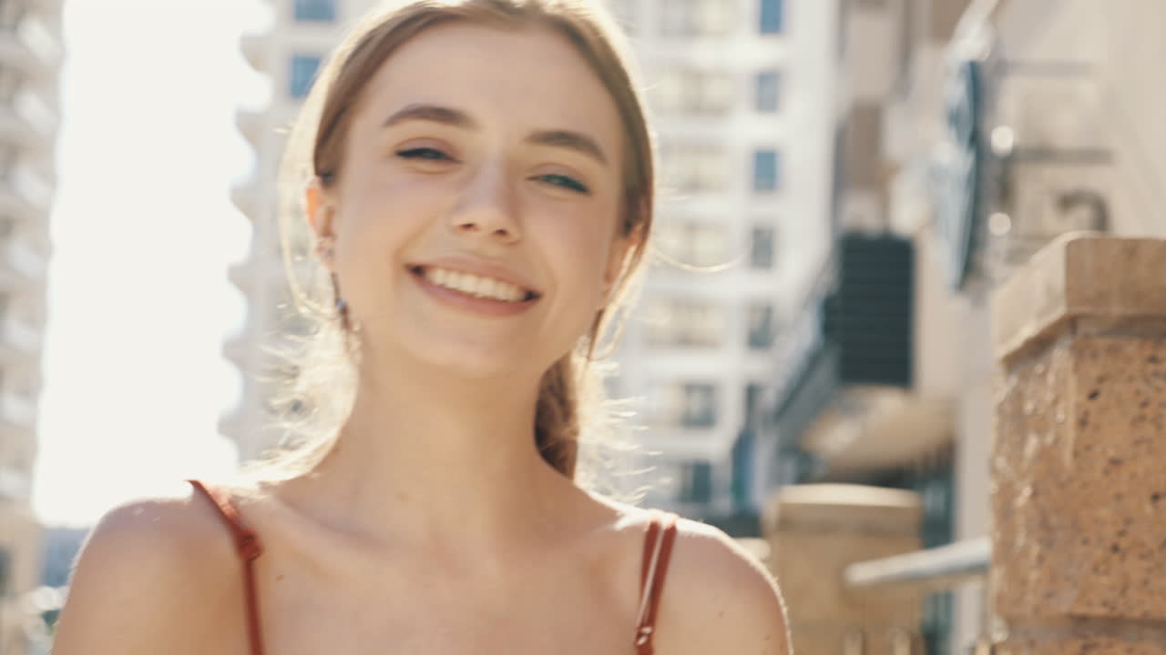 una mujer joven riendo al aire libre.